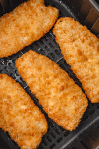 Frozen fish fillets cooking in an air fryer
